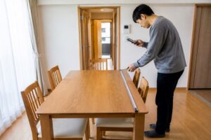 広島の住宅で処分前のダイニングテーブルを採寸する様子